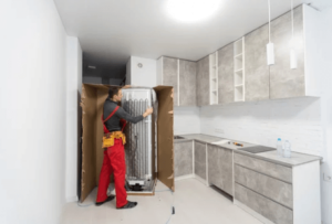 Facchino addetto al trasloco di un frigorifero da una cucina facchino addetto al trasloco di un frigorifero da una cucina